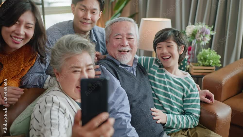 5G Technology for Families concept.Everyone sitting in sofa and using digital devices in living room.Big family grandmother grandfather and kids spending time together at home.