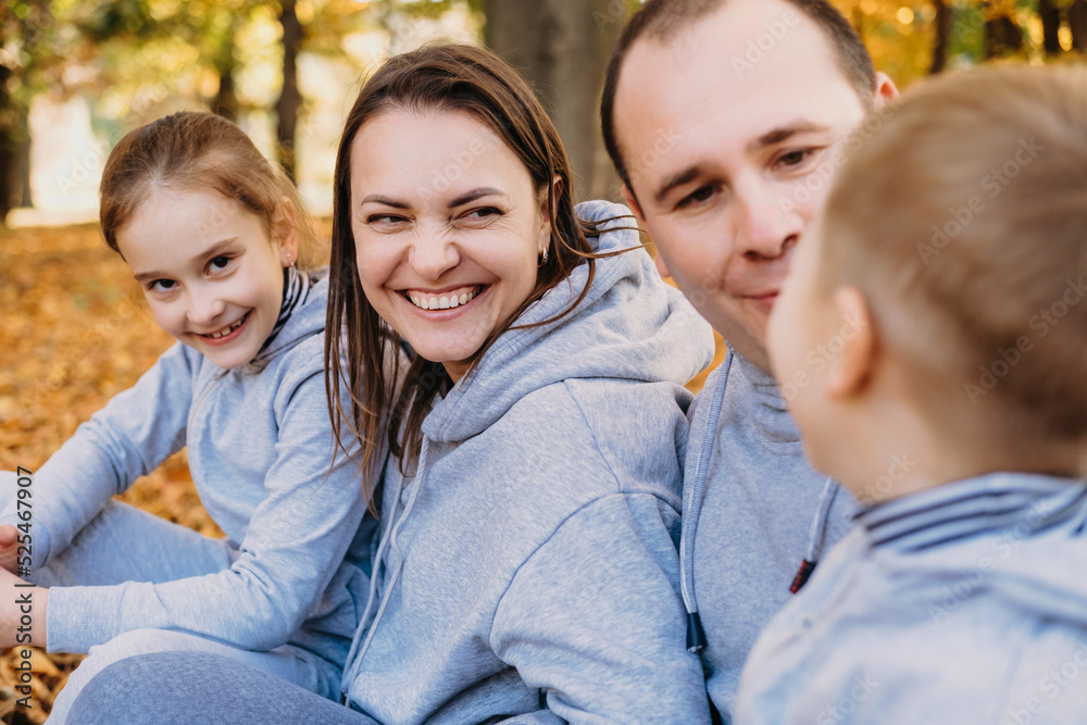 Fototapeta premium Family group of four relaxing outdoors In autumn park. Active lifestyle. Autumn forest. Happy family, childhood.