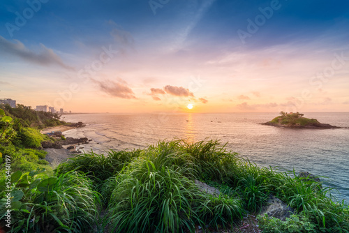 Beautiful cloudscape over the sea, sunrise shot. Lonely boats. Vung Tau beach, Vietnam with beautiful yellow sunrise sky, sun and clouds in orange and blue tones.