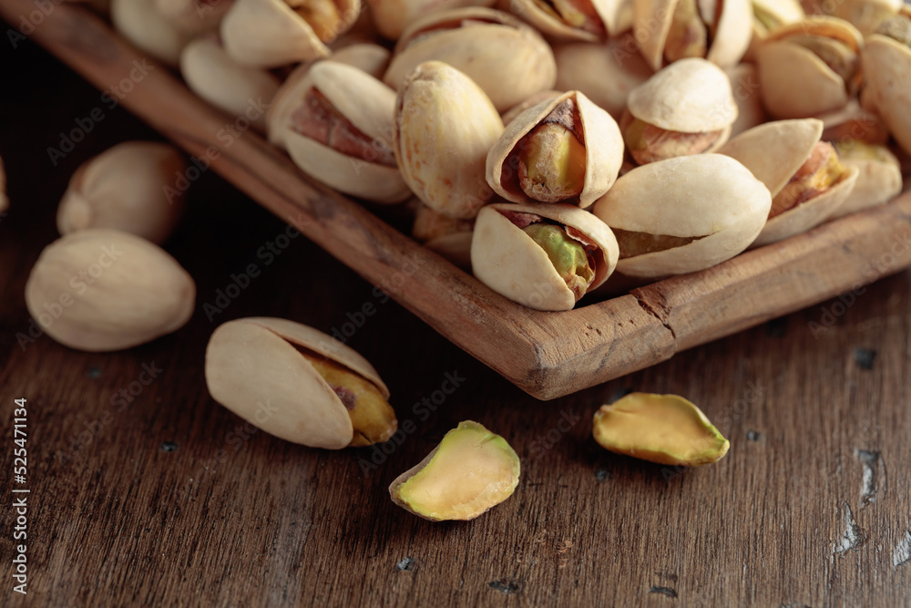 Salted pistachios on an old wooden table. Salted pistachios on an old wooden table.