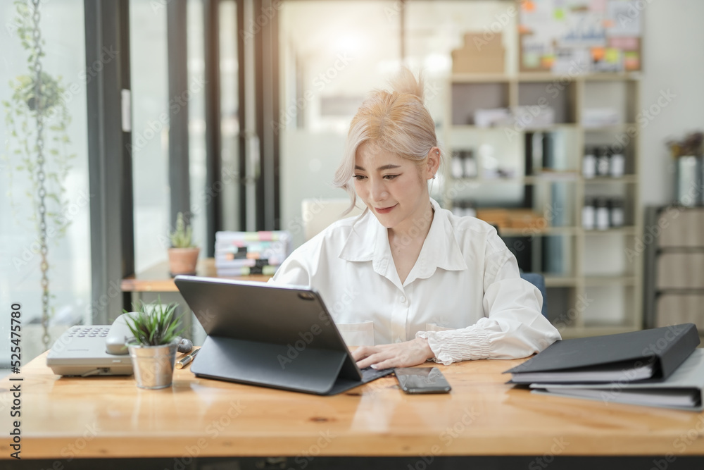 Asian businesswoman using calculator and financial documents at the table office, business financial concept. Asian businesswoman using calculator and financial documents at the table office, business financial concept.