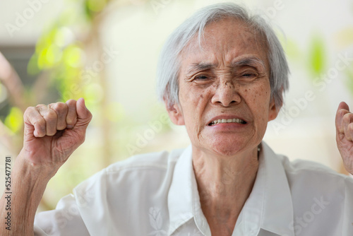 Angry mad senior woman raising fists,facial expression,enraged old elderly grimacing,unpredictable changes of mood,upset,moody,grouchy and irritable,emotional problems,affective disorder,mental health