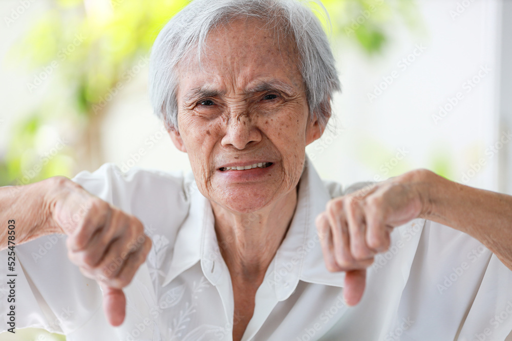 Angry old elderly with dissatisfaction,showing her displeasure,negative emotion facial expression full of anger,unhappy asian senior woman giving thumbs down gesture,rejection symbols,express dislike. Angry old elderly with dissatisfaction,showing her displeasure,negative emotion facial expression full of anger,unhappy asian senior woman giving thumbs down gesture,rejection symbols,express dislike.