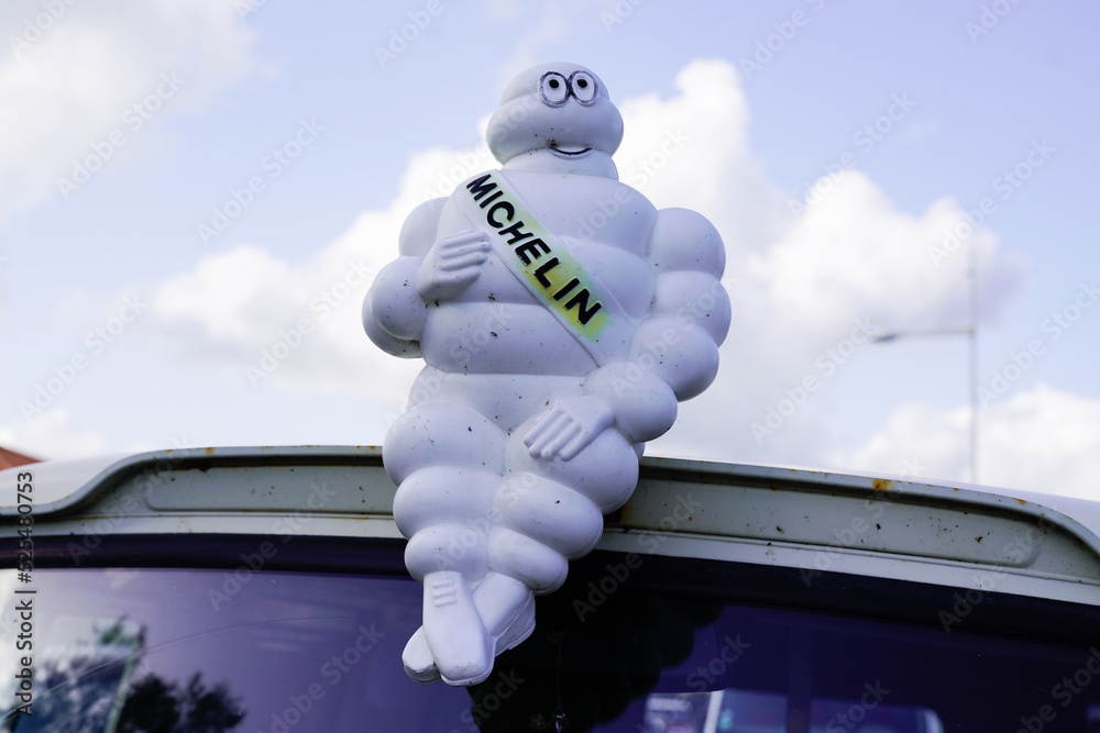 bibendum michelin sign brand and text logo french tyres car figurine mascot  on the roof of an ancient van Stock Photo