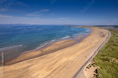 Aerial view on Streedagh beach in county Sligo, Ireland. Beautiful nature scene with warm yellow sand and blue ocean and clear blue sky. Popular tourist area. Warm sunny day.