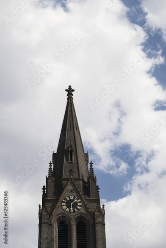 The tower of the church of St. Ludmila, in the background a blue sky with white clouds. Peace Square, Prague, Czech Republic.