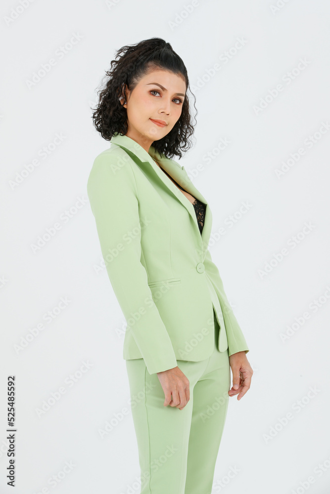 Portrait isolated studio full body shot of Asian young sexy curly hairstyle fashion model in green formal suit with black lace lingerie bra and high heels standing posing alone on white background Portrait isolated studio full body shot of Asian young sexy curly hairstyle fashion model in green formal suit with black lace lingerie bra and high heels standing posing alone on white background