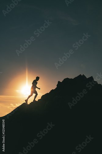 A man runs among the rocks in a colorful mountain sunset