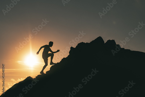 A man runs among the rocks in a colorful mountain sunset