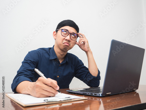 Young business man feels bored to working sit at workplace table © Thanasak