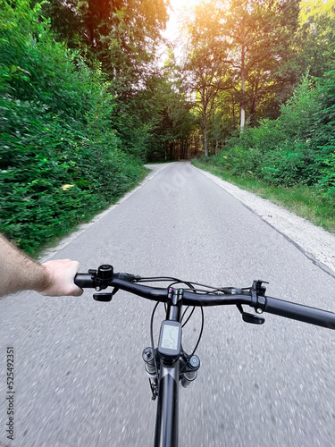 man riding a bike. holding a mountain bike handlebar with one hand. summertime outdoor leisure sport activity. first-person view cycling
