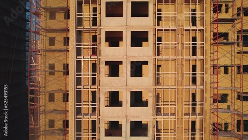 drone flight from left to right at a construction site unfinished buildings empty windows golden hour. High quality 4k footage