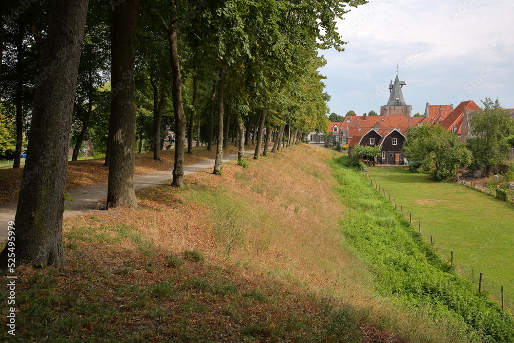 The footpath around the fortified city of Elburg, Gelderland, Netherlands, with the well preserved old city gate Vischpoort in the background