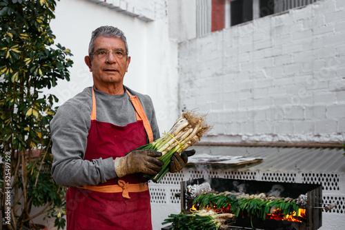 Man with calcots near grill