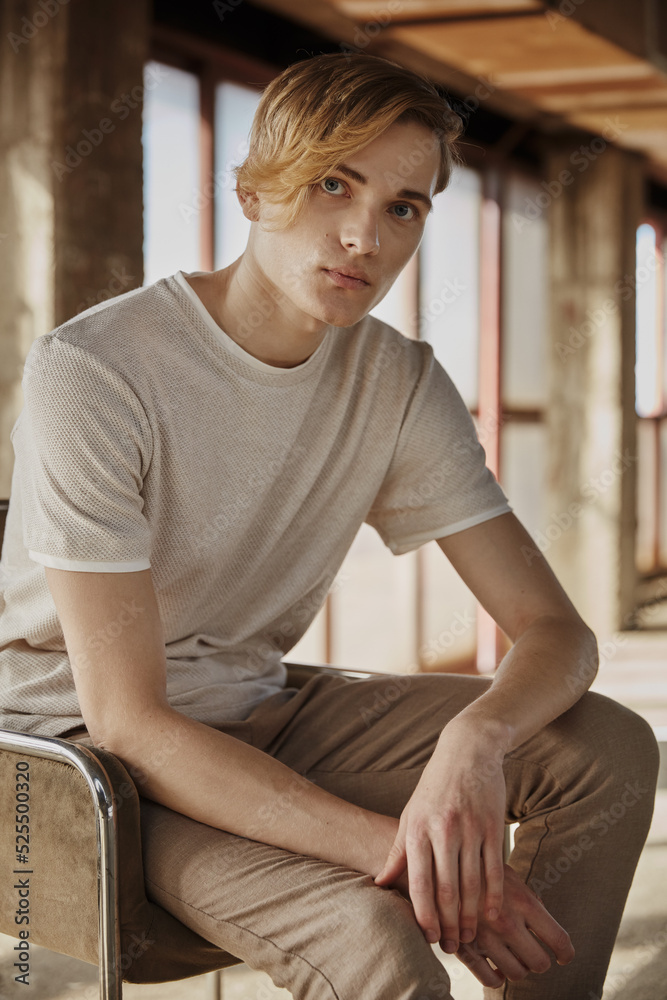 Young trendy man sitting on chair in hall Young trendy man sitting on chair in hall