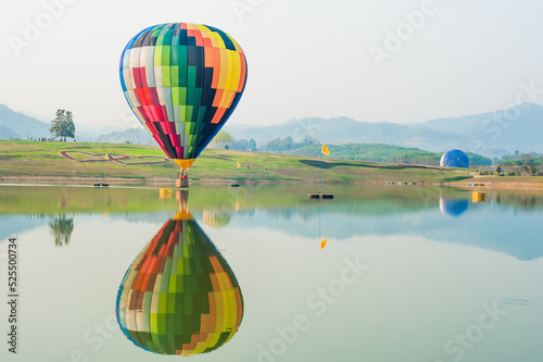 The balloon floats on the reflection of the water.