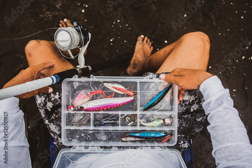 Unrecognizable fisherman with kit of fishing tackle photo