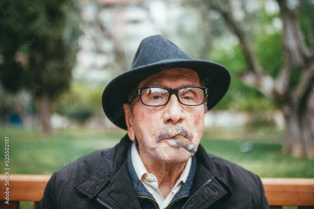 Elderly man smoking cigar on street Elderly man smoking cigar on street