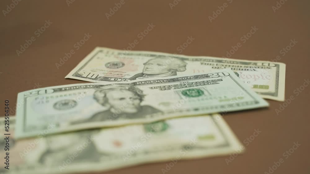 Dollar bills are slowly falling on a brown surface. Close-up. business concept Dollar bills are slowly falling on a brown surface. Close-up. business concept