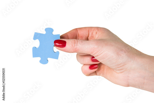 Female hand holding the missing piece of jigsaw puzzle