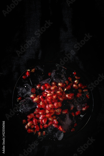 Fresh and red pomegranate on dark background photo
