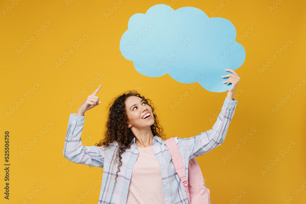 Young black teen girl student wear casual clothes backpack bag point finger on empty blank Say cloud speech bubble content isolated on plain yellow background. High school university college concept. Young black teen girl student wear casual clothes backpack bag point finger on empty blank Say cloud speech bubble content isolated on plain yellow background. High school university college concept.