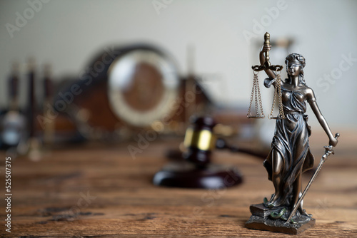 Law concept. Law symbols composition: judge’s gavel, Themis sculpture and scale on rustic wooden desk. photo