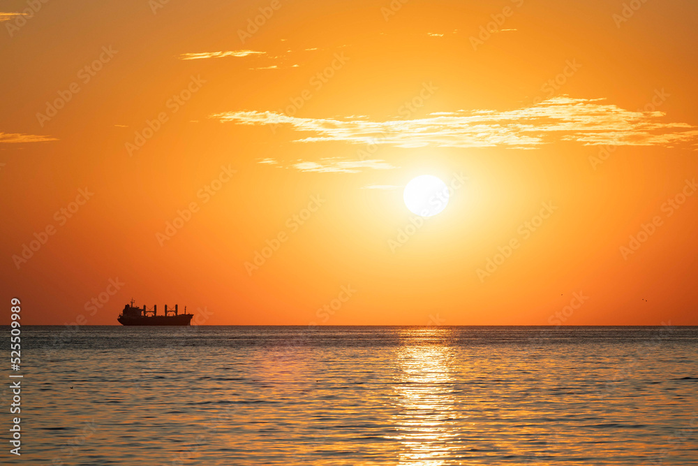 Sonnenaufgang an der Ostsee mit einem Frachtschiff 