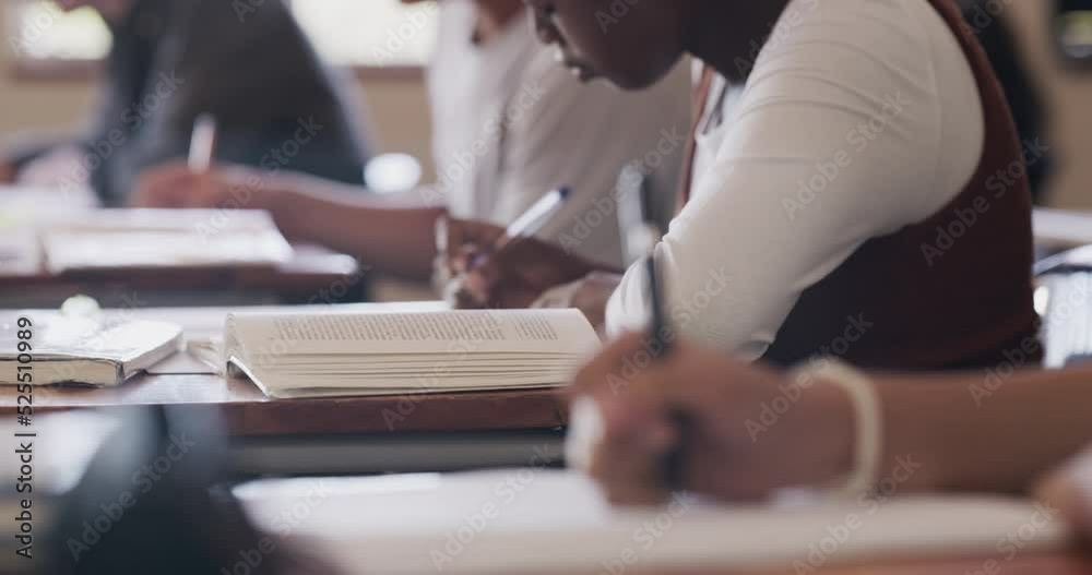 Writing, education and study in classroom of students working in their notebook at their desk for quiz test. High school children learning and reading at desk for exam mindset preparation