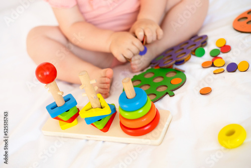 Close-up. Baby is playing. Infant learning and development. Wooden eco-friendly educational toys. Montessori system.