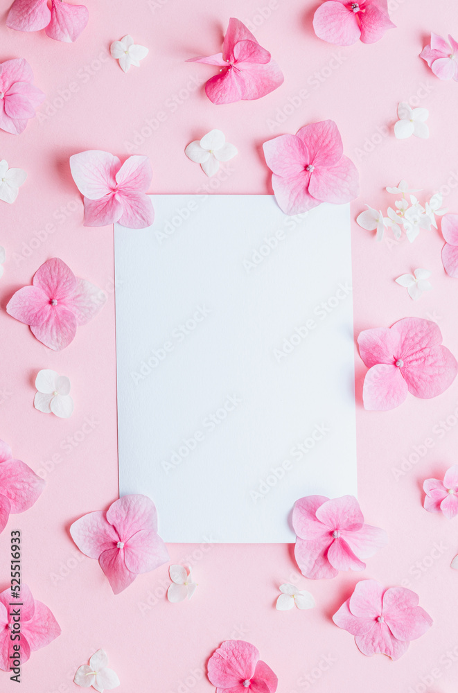 Valentine's Day background. Frame made of pink hydrangea flowers and empty card on pastel pink background.