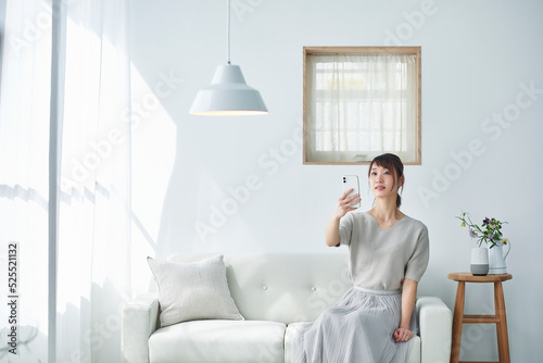 ソファに座りスマートフォンを操作する女性 photo