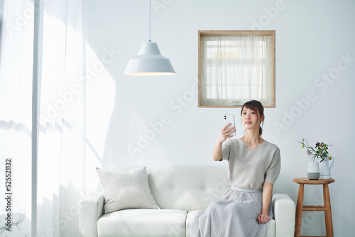 ソファに座りスマートフォンを操作する女性