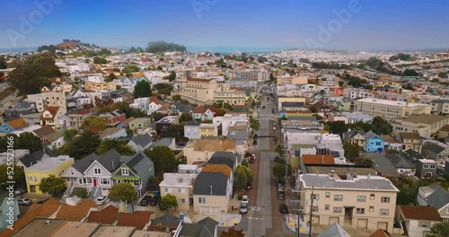 Beautiful cozy streets and houses of bright San Francisco, California, USA. Sunny cityscape with hazy horizon at the backdrop of blue sky. photo