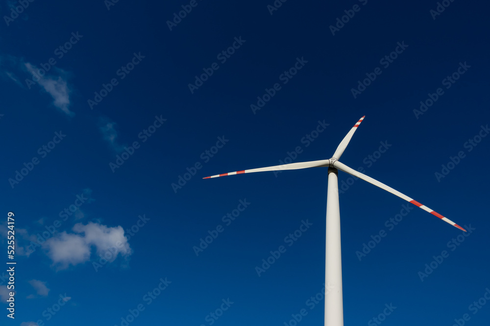 White blades of a wind turbine against the background of a navy blue sky. Renewable energy sources in the decarbonisation process. White blades of a wind turbine against the background of a navy blue sky. Renewable energy sources in the decarbonisation process.