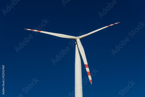 White blades of a wind turbine against the background of a navy blue sky. Renewable energy sources in the decarbonisation process. photo