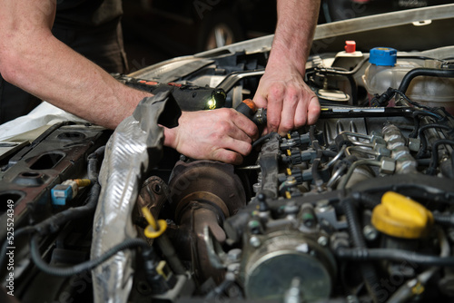 Close up of car mechanic hands doing car service and maintenance. Mechanics workshop.