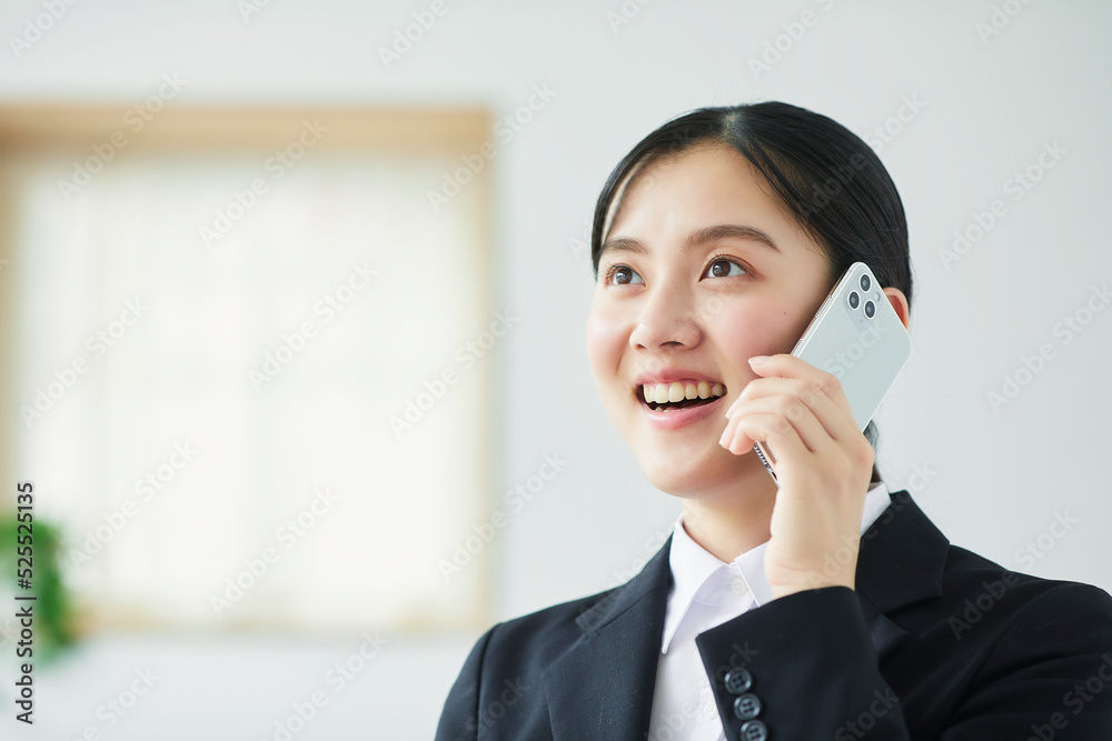 スマートフォンを持ち喜ぶスーツを着た若い女性 スマートフォンを持ち喜ぶスーツを着た若い女性