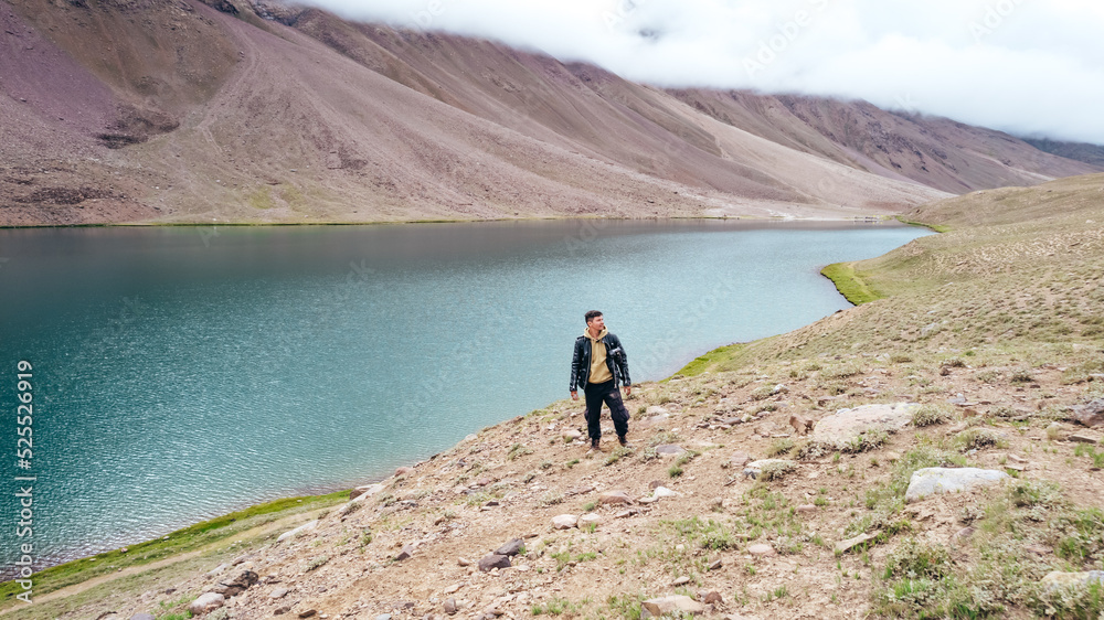 man at Chandra Taal Lake with no tourists on cloudy day in Spiti Valley India, landscape