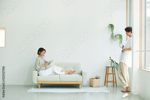 室内でソファに座りタブレットPCを見る若い女性と男性 photo