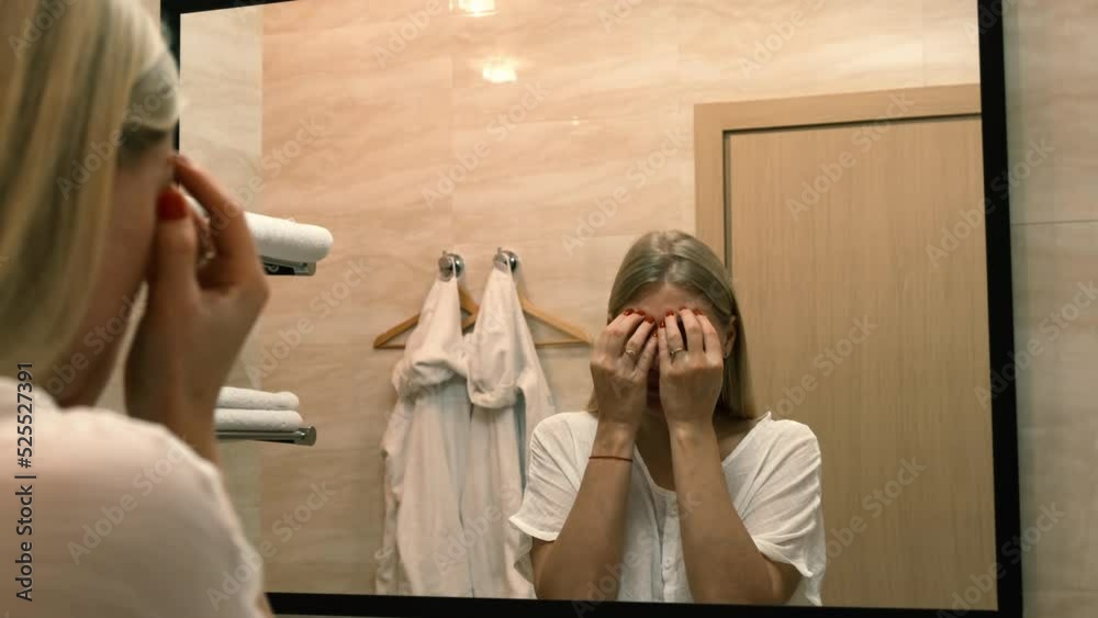 Ageing. Sagging skin. A young woman does facelift exercises by looking