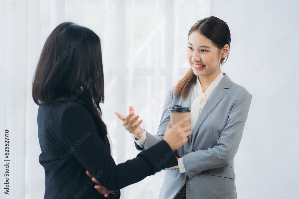 Two asian business woman work together to get the job done at the office Two asian business woman work together to get the job done at the office
