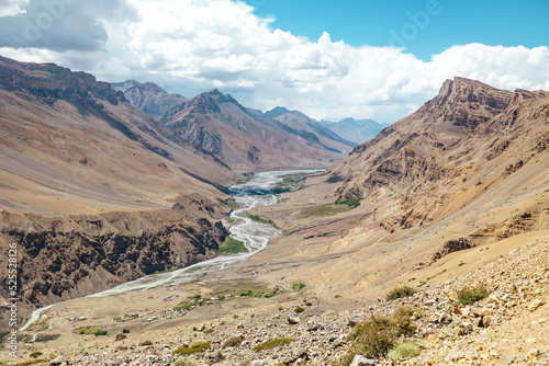 sunny dry desolate mountain landscape in Spiti Valley with river flowing in summer