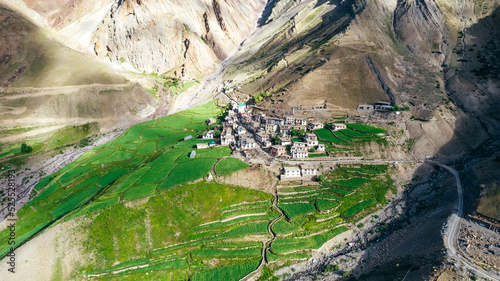 Aerial top down of small Mud Village surrounded by extreme mountain landscape during Indian Summer