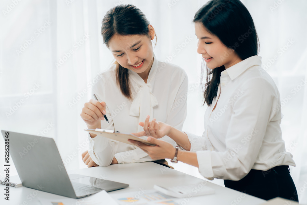Two business Asian young women working together with laptop computer in the modern office. Two business Asian young women working together with laptop computer in the modern office.