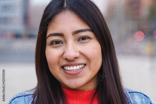 Indigenous young woman smiling while looking at camera outdoor - Focus on face