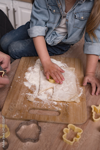 children's hands cut out cookies from dough, christmas pastries., christmas baking