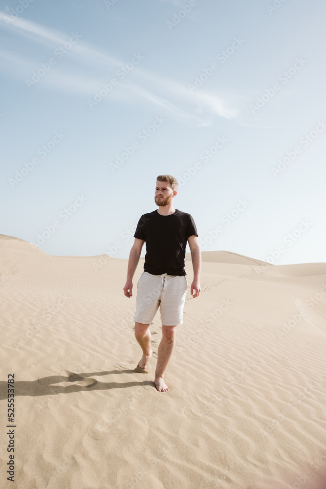 Man standing on sand land and blue sky Man standing on sand land and blue sky