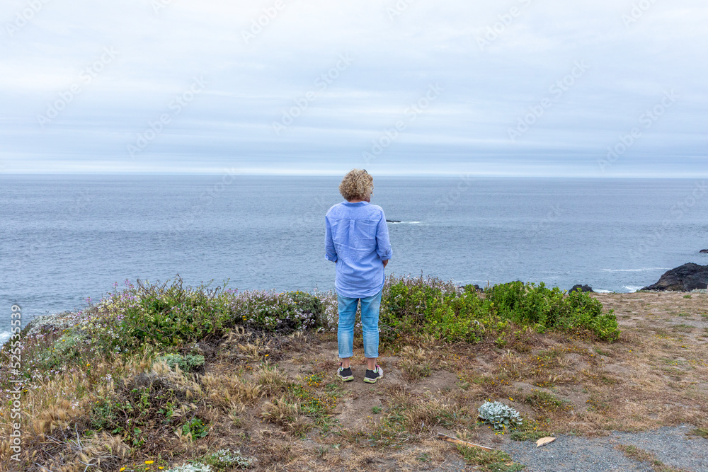 woman looking to the pacific sea at a cloudy day