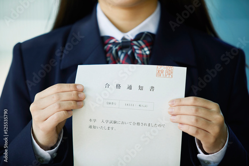 合格通知書を持ち微笑む女子学生 photo